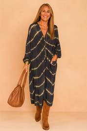 Confident European woman in a loose black and beige tie-dye maxi shirt dress with buttons.