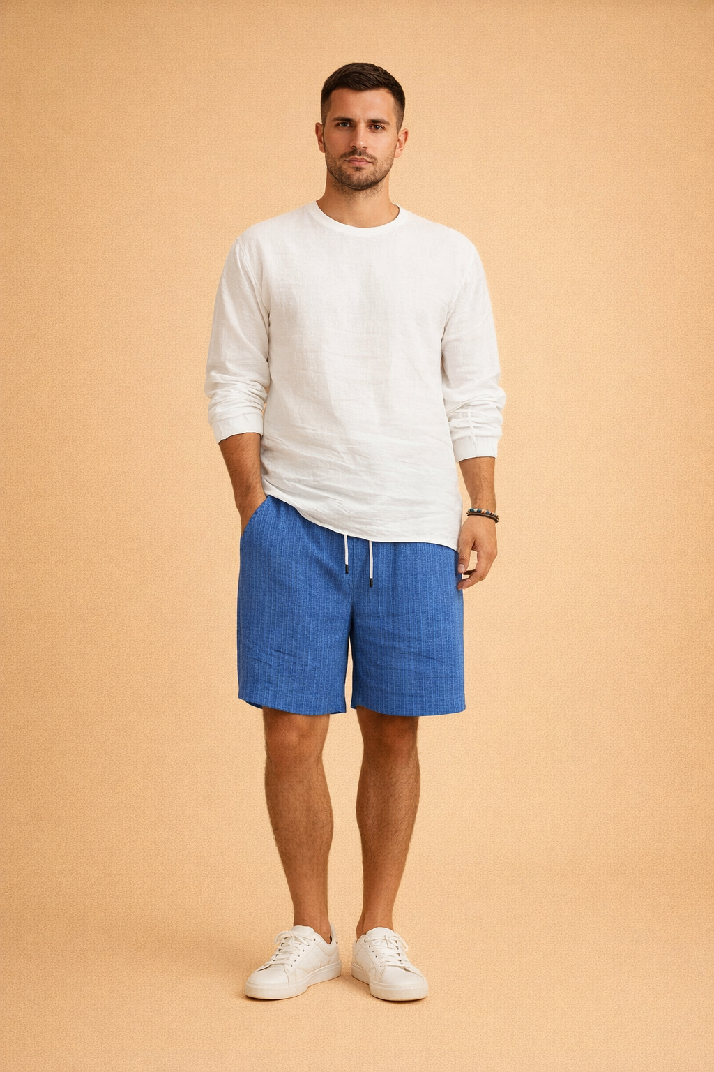 Men’s white long-sleeve casual shirt paired with blue vertically ribbed drawstring summer shorts and clean white low-top sneakers, featuring a relaxed modern fit and a textured fabric finish suitable for warm-weather styling.