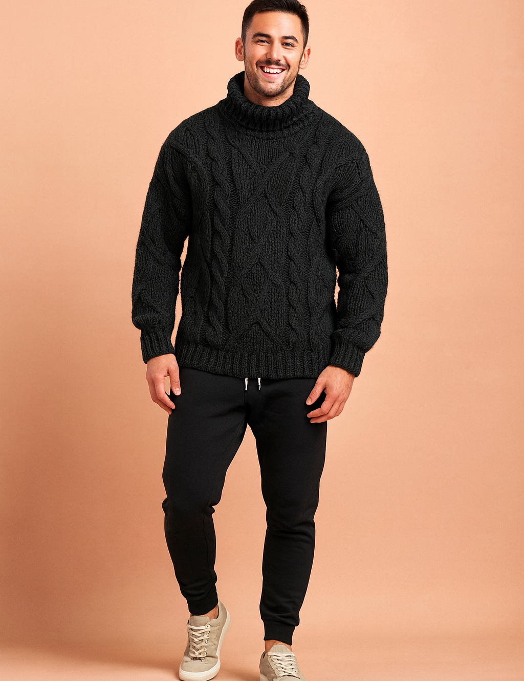 Men's chunky cable-knit turtleneck sweater in black, designed for warmth and modern style with a textured woven pattern, paired with tapered black joggers and casual grey sneakers.