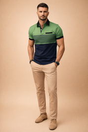 Modern men’s short-sleeve polo shirt featuring a sage green upper panel with black collar and sleeve cuffs, horizontal dark green stripe detailing across the chest, and a deep navy lower section, paired with slim-fit beige chinos and light brown suede lace-up shoes for a refined smart-casual look.