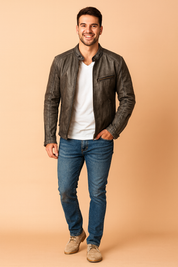 Dark gray leather biker jacket with zippered chest and side pockets, snap button collar, and detailed stitching, paired with a white T-shirt and slim blue jeans.