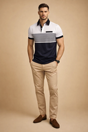 Short-sleeve mens polo shirt with white upper panel, navy horizontal stripe detailing across the chest, solid navy lower section, contrasting black collar and sleeve cuffs, paired with slim-fit beige chinos and dark leather lace-up shoes for a refined smart-casual look