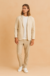 Męska marynarka lniana w kolorze beżowym, lekki krój casual slim fit, z dwoma guzikami i przednimi kieszeniami naszywanymi, idealna na letnie stylizacje."