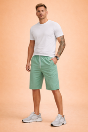 Men’s mint green casual summer shorts with a smooth matte fabric finish, elastic waistband with white adjustable drawstring, relaxed straight-leg cut above the knee, clean solid-color surface with no print, lightweight breathable texture, and minimalist everyday design suitable for warm-weather wear.