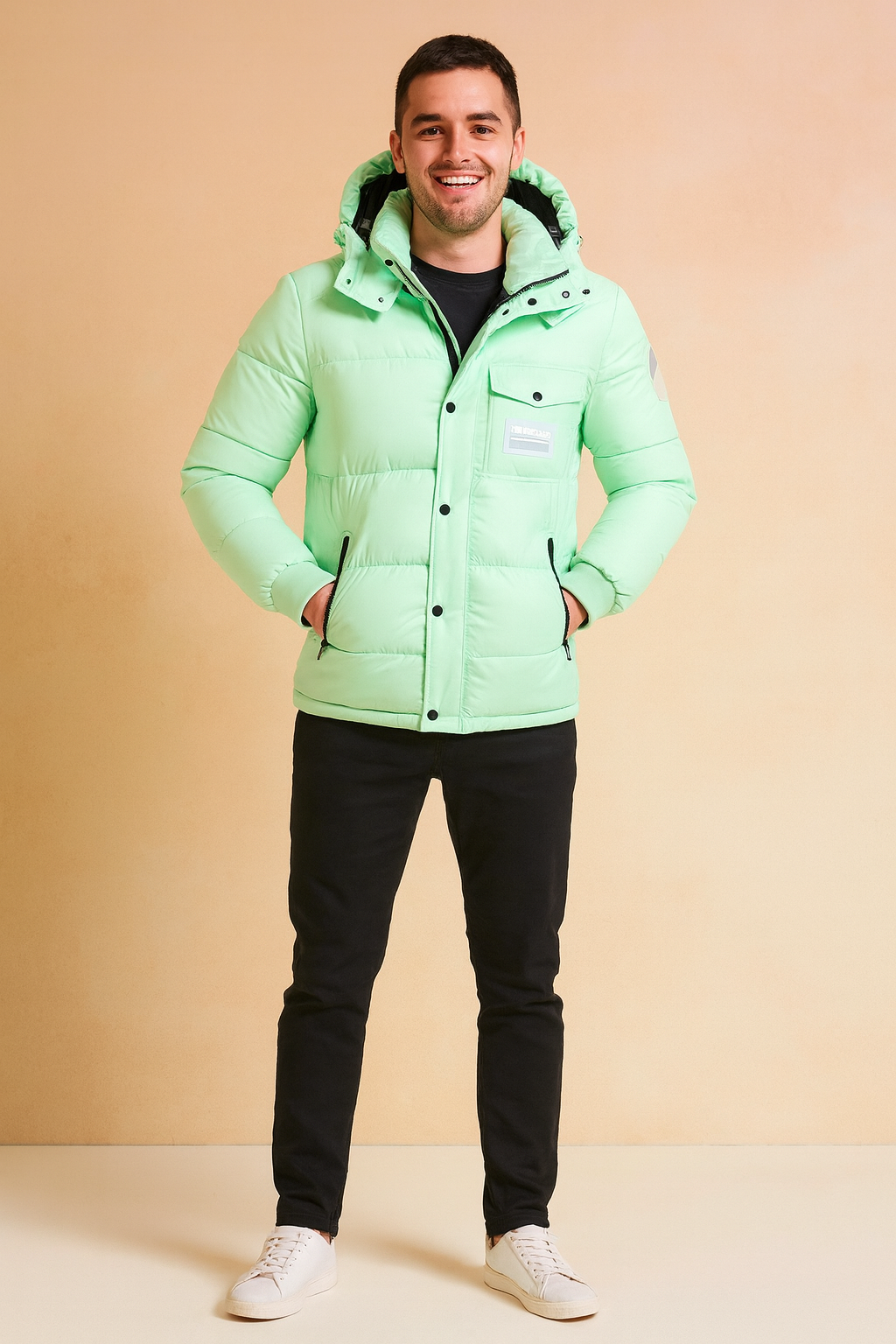 Mint green puffer jacket with hood, front snap buttons, and zippered pockets, styled with black trousers and white sneakers.
