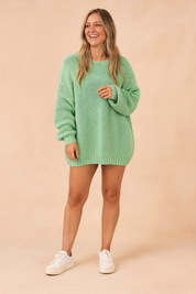 Mint green oversized knit sweater with a relaxed fit, long sleeves, ribbed cuffs, and hem, paired with white low-top sneakers.