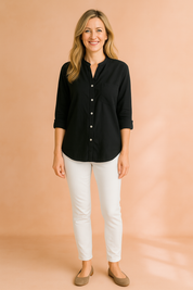 Black button-up long sleeve shirt with a single chest pocket, styled with fitted white trousers and taupe flats.