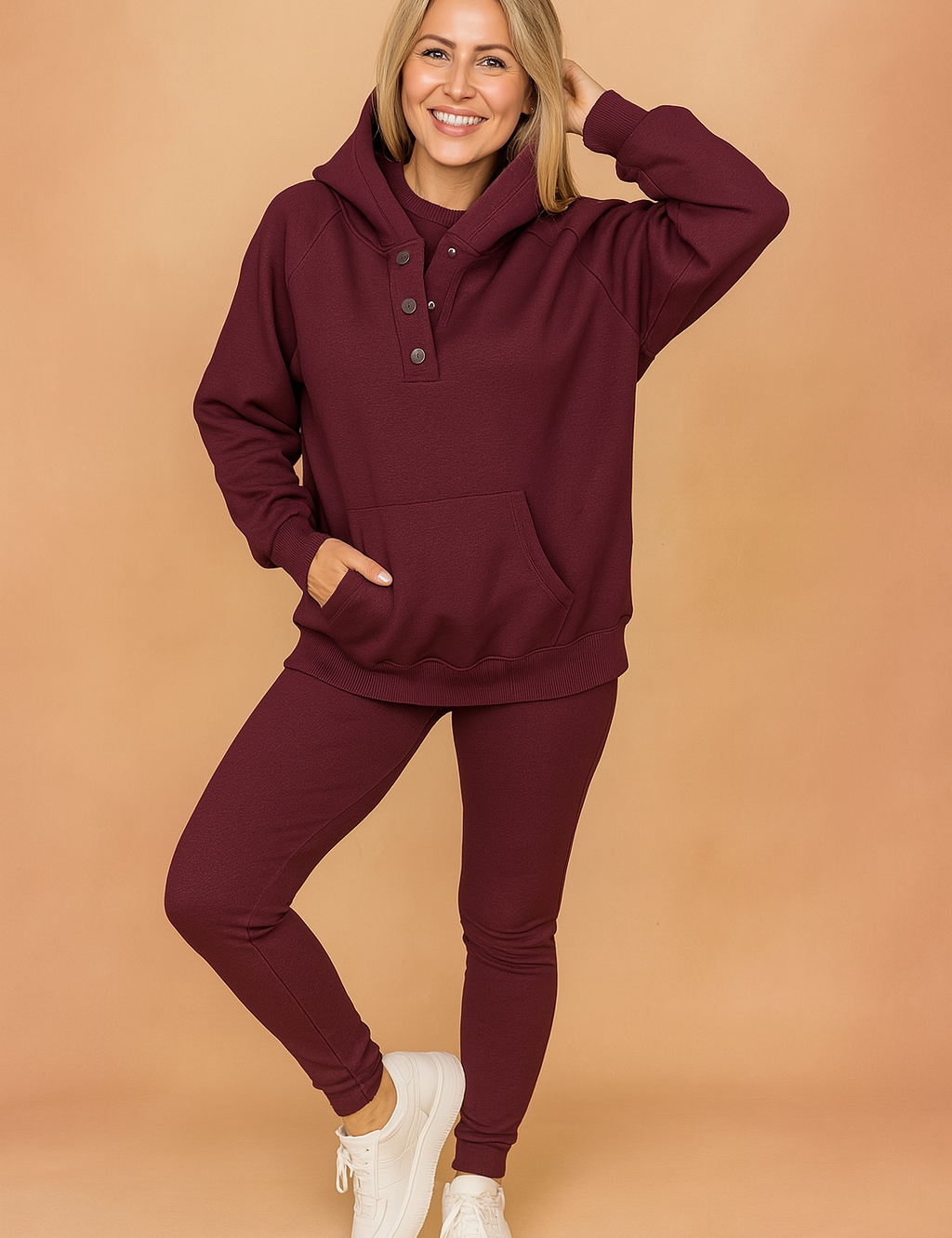 Ribbed burgundy hoodie and matching leggings set featuring a three-button collar and front pouch pocket, styled with clean white sneakers.