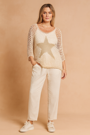 Beige open-knit sweater with metallic star design, styled with loose ivory trousers and cream sneakers for a relaxed yet chic look.