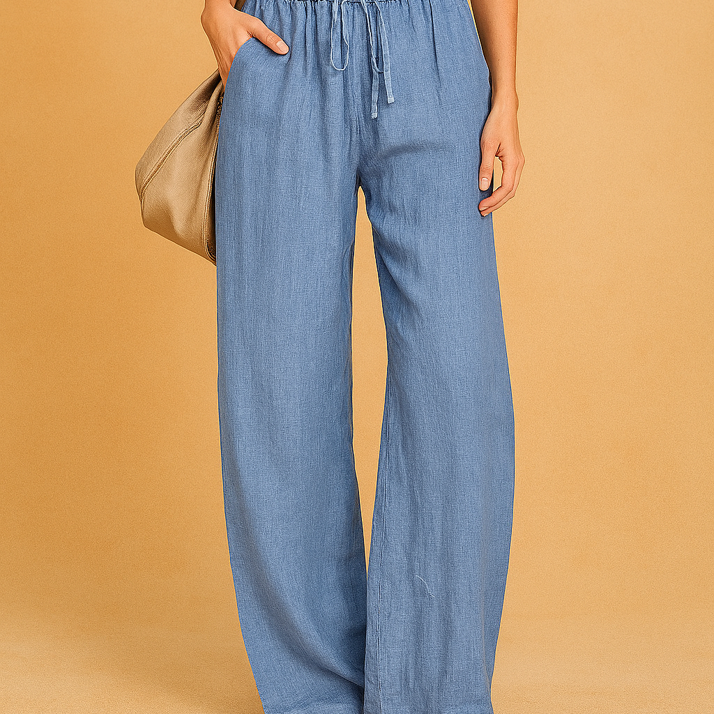 Light blue linen drawstring pants in a relaxed wide-leg silhouette, featuring an elastic waistband and side pockets, styled casually with tan flat sandals and a slouchy beige handbag.