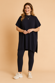Two-piece navy ribbed knit set featuring an oversized short-sleeve tunic top with vertical texture detailing, paired with matching fitted ribbed leggings.