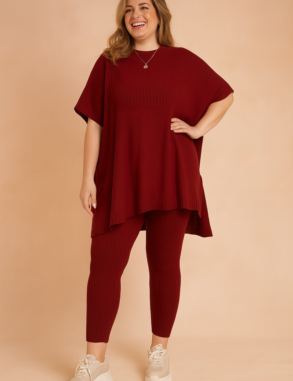 Ribbed knit two-piece loungewear set featuring an oversized short-sleeve tunic top and matching fitted leggings in red, styled with chunky cream sneakers.
