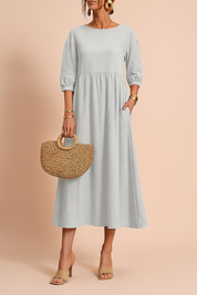 Sukienka midi z szarego lnu o długości 3/4 rękawa, luźny krój z marszczeniem w talii, styl boho.
