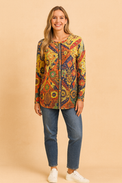 Multicolored button-up cardigan with intricate floral and geometric patterns, paired with mid-wash straight-leg jeans and white lace-up sneakers.