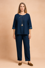 Navy blue linen two-piece set featuring a boat-neck top with three decorative silver buttons and cuffed sleeves, paired with straight-leg ankle-length pants.