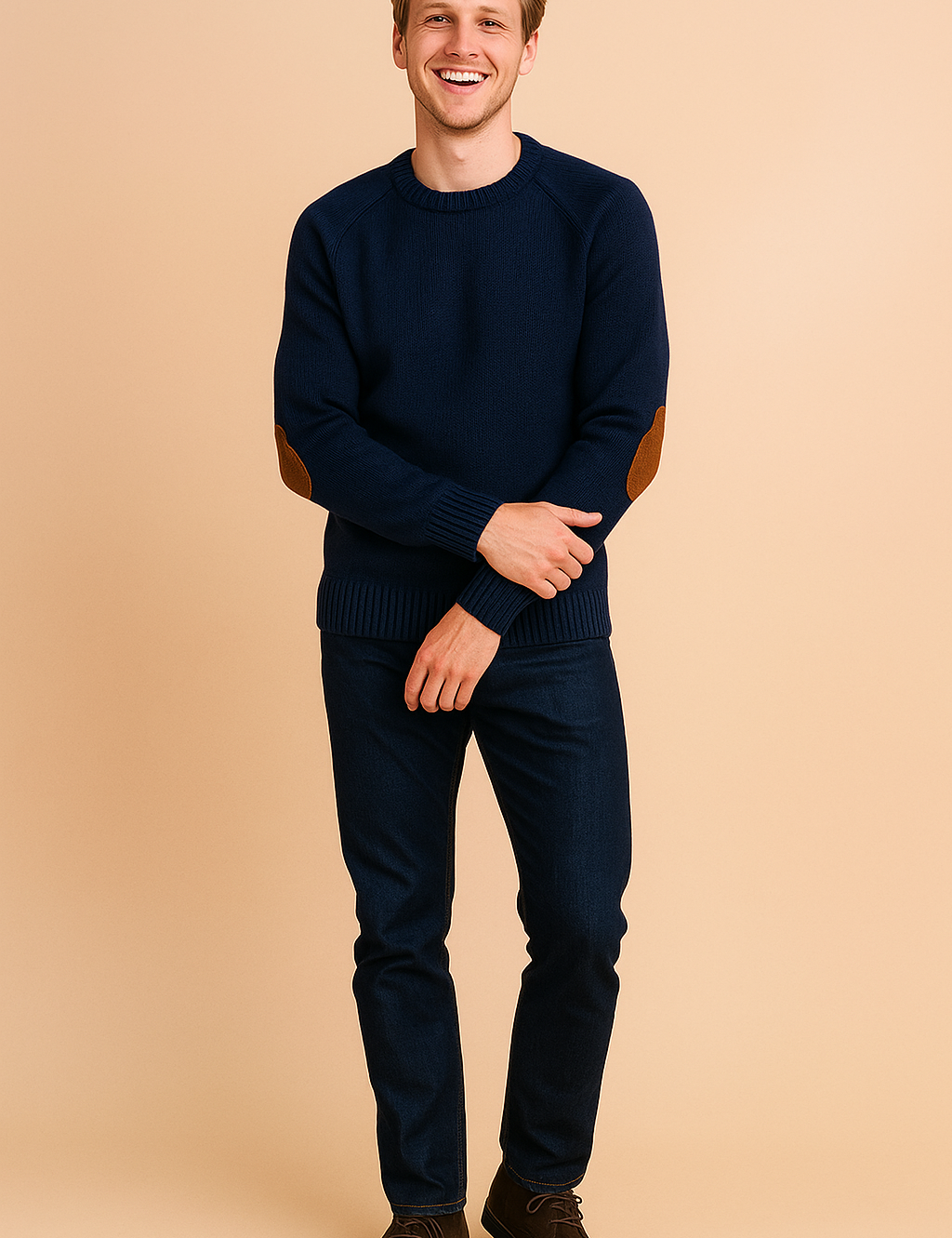 Navy blue crewneck sweater with ribbed cuffs and hem, featuring brown suede elbow patches, styled with dark blue jeans and brown suede lace-up boots.