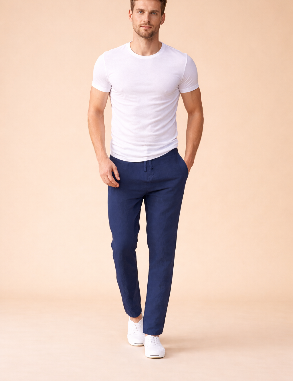 Navy blue tapered drawstring trousers styled with a fitted white short-sleeve T-shirt and clean white low-top sneakers for a modern casual look