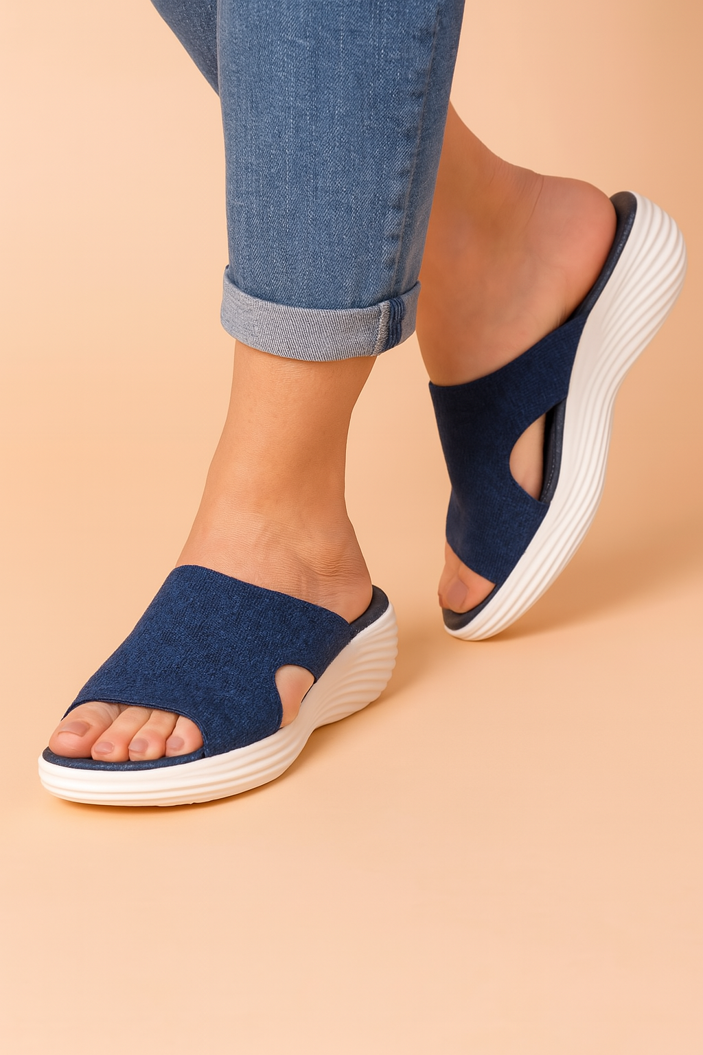 Navy blue knit platform slide sandals with textured stretch fabric upper, featuring side cutouts and contoured white ridged soles for added height and comfort.
