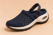 Navy blue breathable mesh clog sandal with a white cushioned sole, black treaded outsole, and a supportive rear strap with button detail.