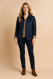 Navy blue quilted button-down jacket with diamond stitching, styled over a neutral top, dark slim pants, and brown ankle boots.