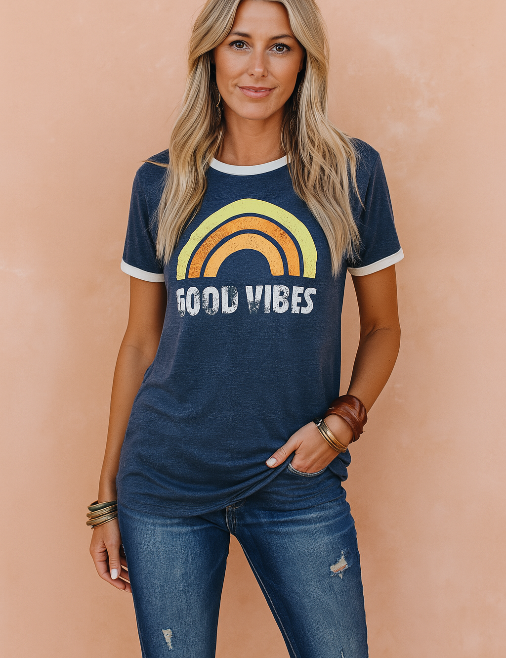 Vintage-inspired navy blue graphic tee featuring a retro rainbow print and distressed "Good Vibes" lettering, paired with medium-wash ripped skinny jeans for a laid-back, boho-chic casual look.