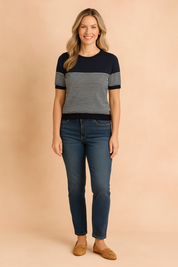 Navy blue and white striped short-sleeve sweater with ribbed neckline, cuffs, and hem, paired with classic dark-wash jeans.