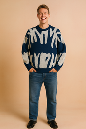 Navy blue sweater with bold white abstract brushstroke pattern, paired with medium-wash jeans and black leather shoes.