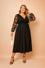 Black plus size midi dress for women with sheer floral sleeves, V-neck and tie waist.