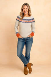 Light gray Nordic knit sweater with navy and orange pattern across the chest and cuffs, paired with medium blue jeans and tan suede ankle boots.