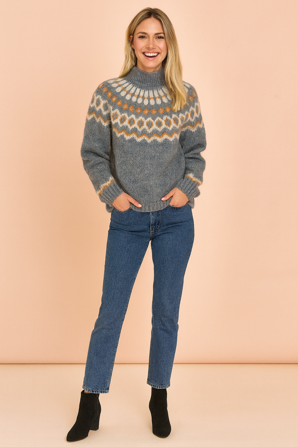 Nordic-patterned heather gray knitted sweater with cream and mustard geometric yoke design, paired with blue straight-leg jeans and black ankle boots.