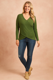 Olive green ribbed crossover long-sleeve sweater with asymmetrical hem, paired with dark-wash skinny jeans and tan suede ankle boots.