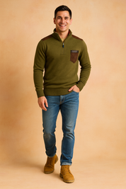 Olive green quarter-zip knit sweater with brown suede shoulder patches and a matching suede chest pocket detail, paired with slim-fit blue jeans and tan leather boots.