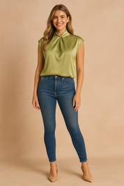 Light olive-green satin blouse with a soft draped high neckline and cap sleeves, paired with fitted blue jeans and nude heels.