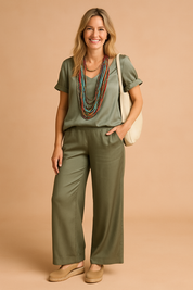 Olive green satin two-piece coord set featuring a relaxed-fit short-sleeve top and wide-leg trousers with subtle seam detailing and a soft sheen finish.