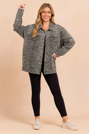 Oversized leopard print denim jacket styled with black leggings and beige sneakers.