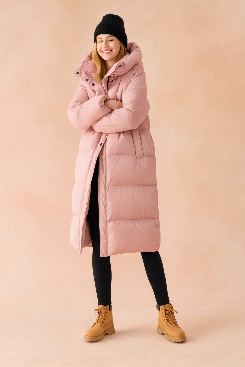Long pastel pink puffer winter jacket with hood, full-length quilted design, snap-button closure, and side pockets.