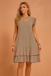 Elegant summer dress with ruffle sleeves and a tiered hem, featuring a black abstract pattern.