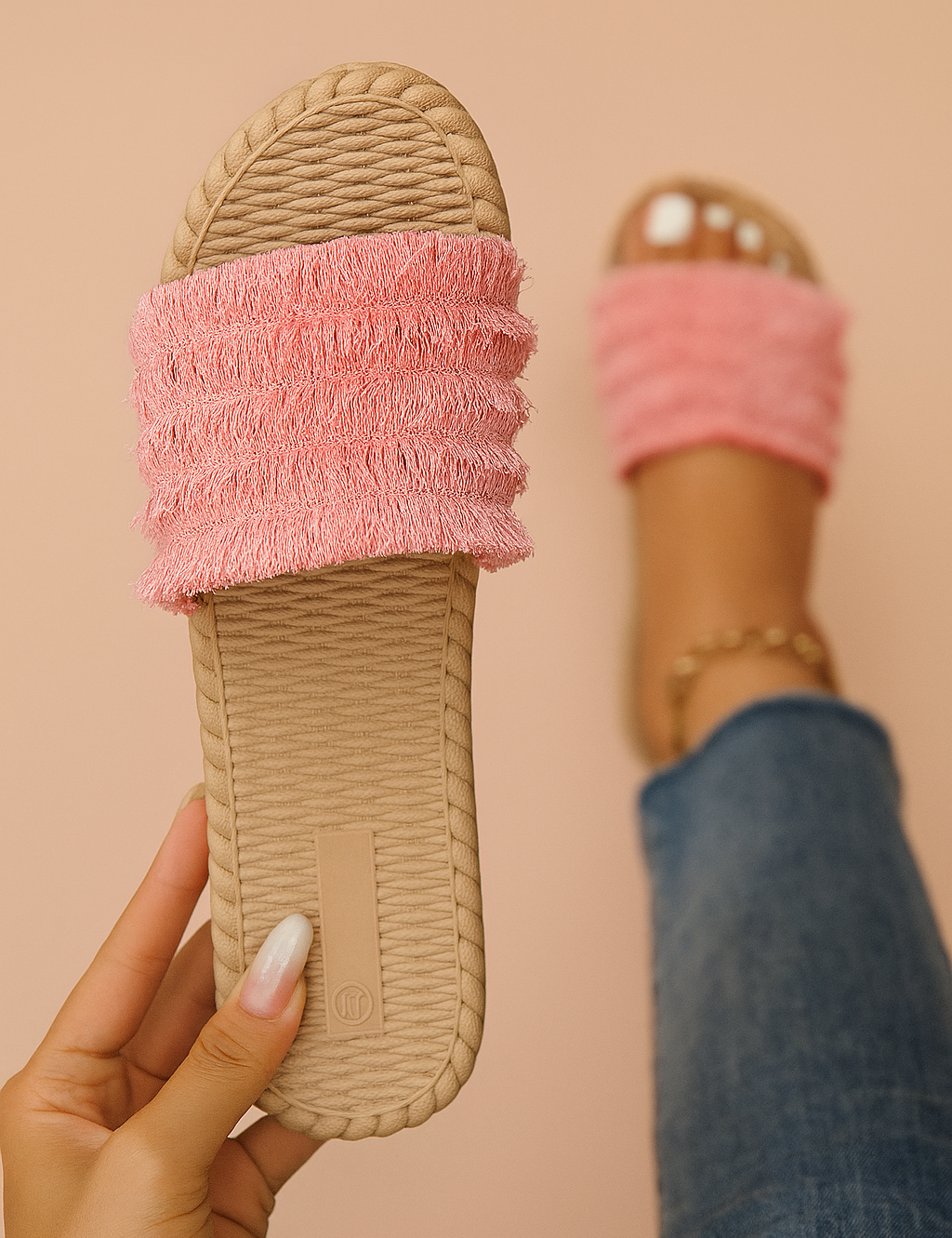 Pink fringe-textured slide sandals with a ridged sole and layered fabric bands, designed for casual summer wear.