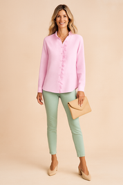 Pastel pink button-up blouse with vertical textured stripes and a delicate front ruffle trim, styled with mint green slim-fit pants, nude block-heeled shoes, and a beige fold-over clutch for a chic, feminine look.