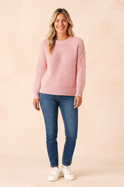 Light pink textured knit sweater with ribbed hem and cuffs, paired with slim-fit blue jeans and white sneakers.