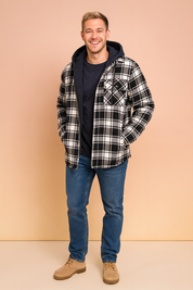 Black and white plaid hooded flannel jacket with quilted lining, button-up front, and chest pocket, paired with medium blue jeans and beige suede boots.