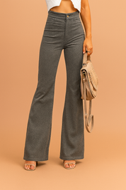 High-waisted dark gray flare pants with front darts, a smooth structured waistband, and subtle tonal texture, styled with nude heeled sandals and a soft suede beige handbag.