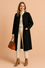 Elegant black wool coat with round collar and front patch pocket, styled over a cream ribbed turtleneck and cuffed ivory trousers, finished with taupe suede ankle boots and a structured brown leather handbag.