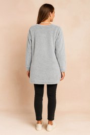 Long oversized sweater with a fluffy, plush texture, featuring two practical front pockets and a simple, comfortable fit.