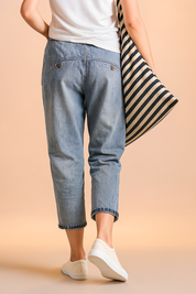 High-rise light wash cropped denim jeans with relaxed hips and tapered rolled hems, styled with minimal seam details and back curved pockets secured by two rivet accents.