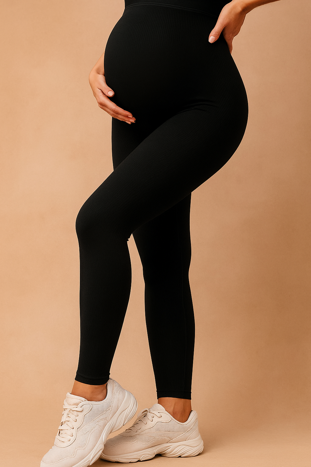 High-waisted black ribbed maternity leggings styled with white sneakers, designed for support and comfort during pregnancy.