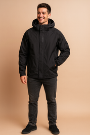 Black waterproof performance jacket with adjustable hood, front zip closure, and minimalist urban detailing, styled with dark jeans and casual sneakers for a sleek, weather-ready streetwear look.