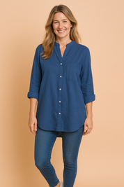 Relaxed-fit mandarin collar long-sleeve shirt in solid deep blue, featuring a front patch pocket, button-down closure, and soft cotton texture.