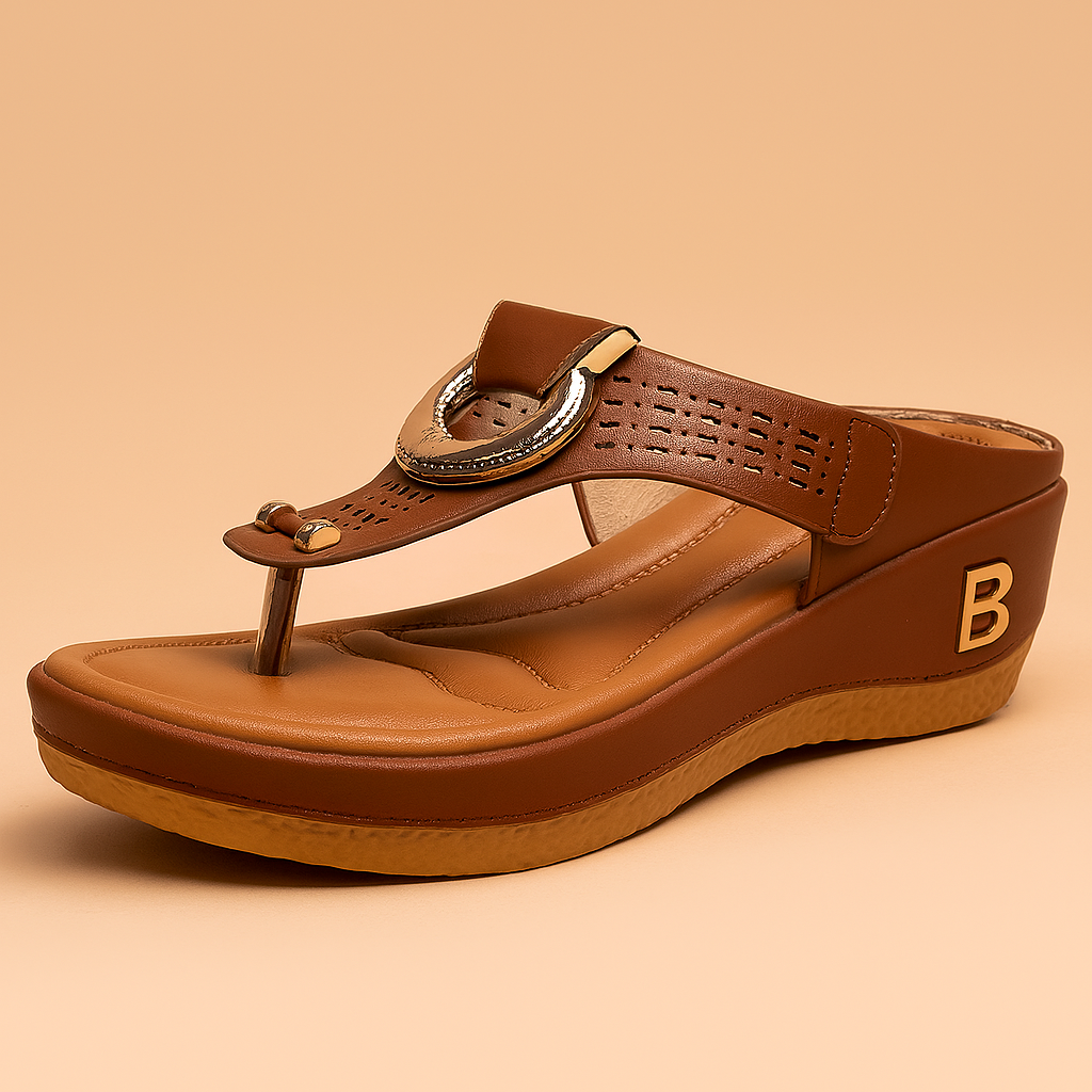 Brown wedge sandal with faux leather upper, perforated strap detailing, metallic gold circular buckle, cushioned tan footbed, and a textured rubber sole with a gold “B” logo on the side.