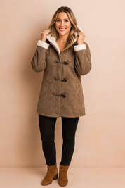Taupe faux suede duffle coat with white fleece lining and toggle button closures, paired with black fitted jeans and tan ankle boots.